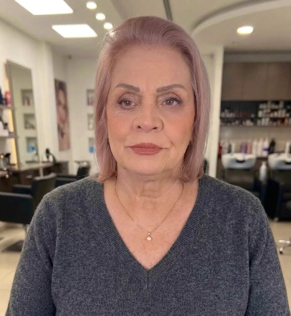 Mature client with soft, radiant makeup, warm neutral eyes and a rosy nude lip